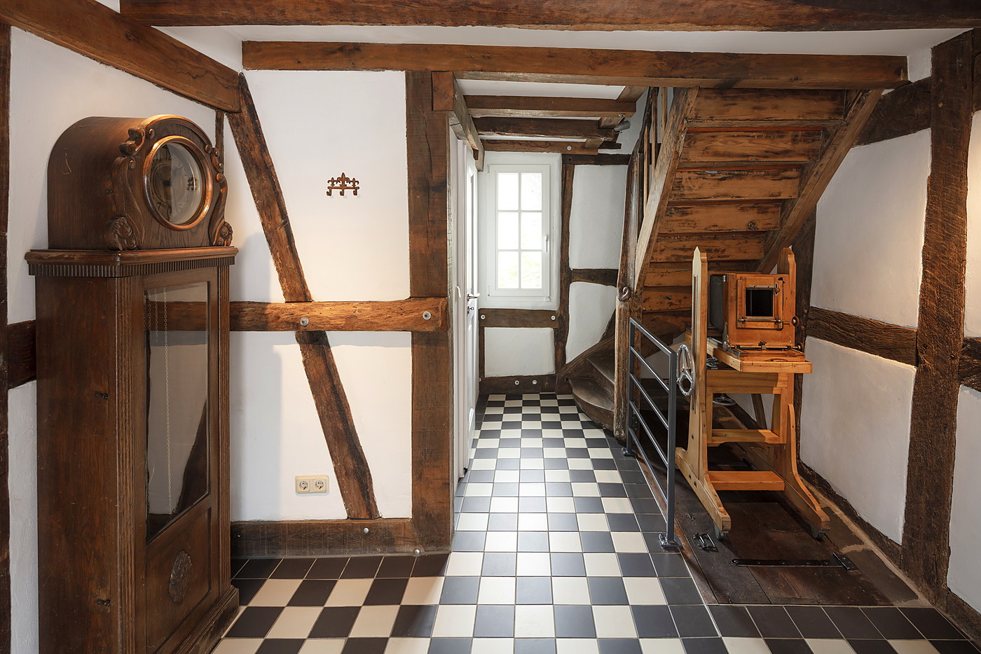 Flur mit historischer Treppe und Schachbrettfliesen